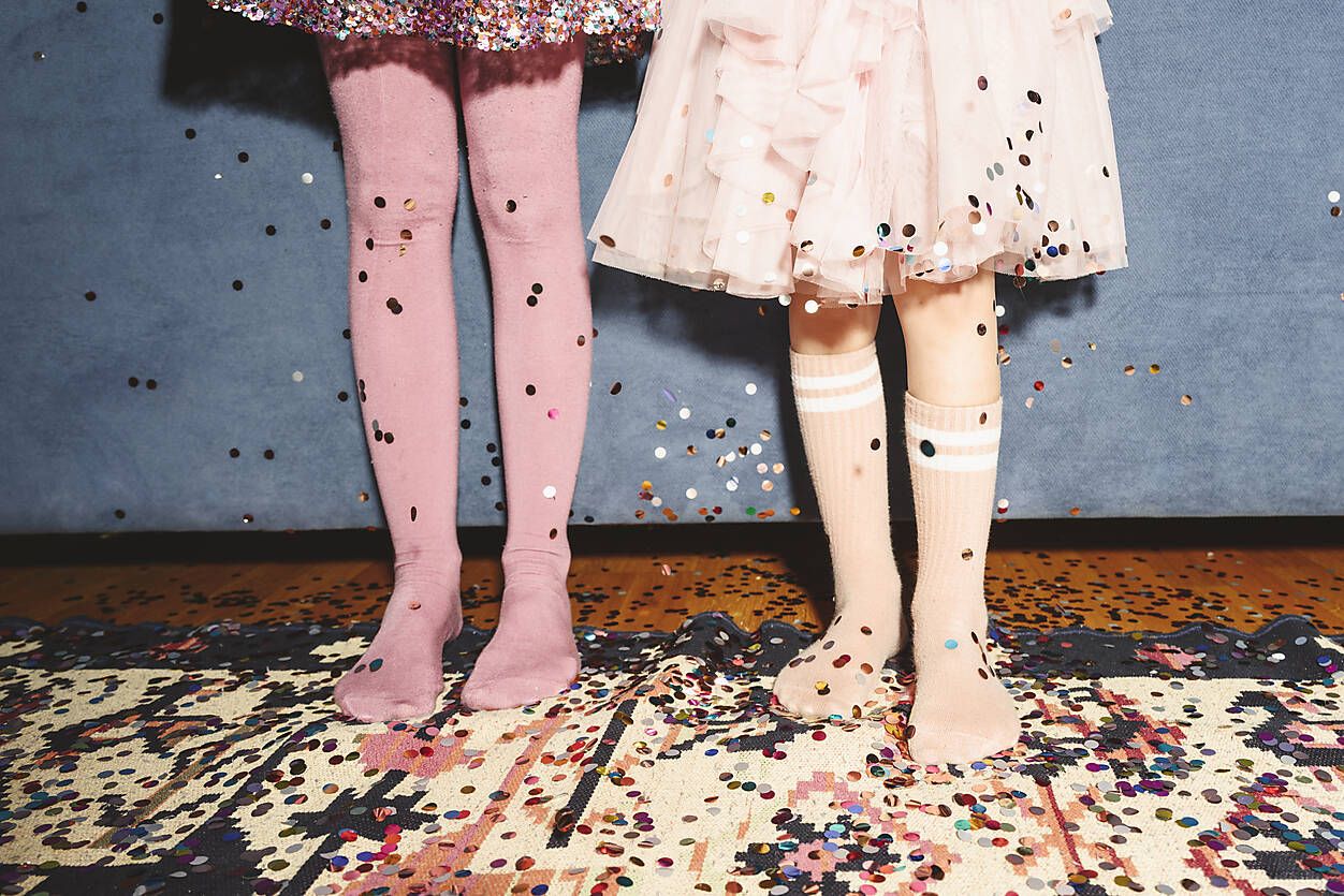 Westend61 / Ekaterina Yakunina /Legs of girls standing on floor covered with confetti